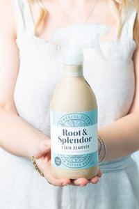 Person holding a bottle of 'Root & Splendor Stain Remover' with a light background