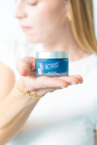 Person holding a blue container labeled 'Activist' against a blurred background