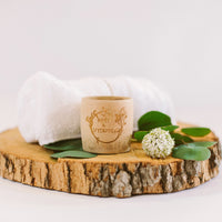 Wooden coaster with a cup, towel, and decorative elements on a light background