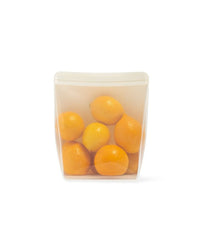 A clear silicone stand-up bag filled with orange fruits, with a solid white background.