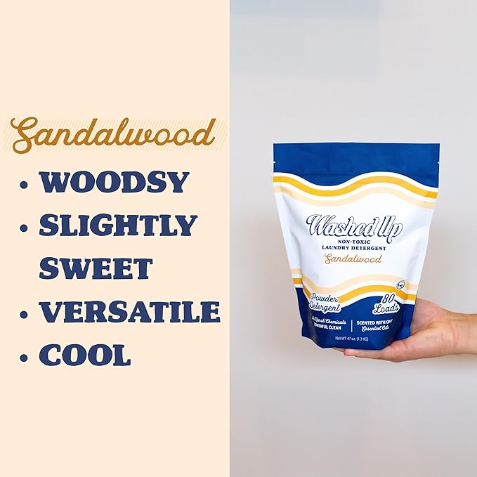A product package of "Washed Up" sandalwood laundry detergent is displayed against a neutral background. Text reads: "Sandalwood: woodsy, slightly sweet, versatile, cool."