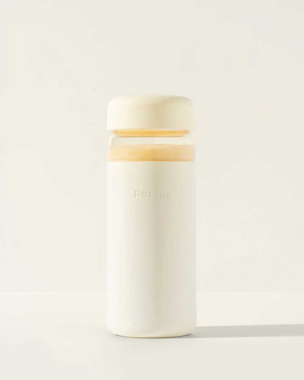 A white wide-mouth glass bottle with a twist-off cap and a silicone sleeve, displayed against a neutral background.