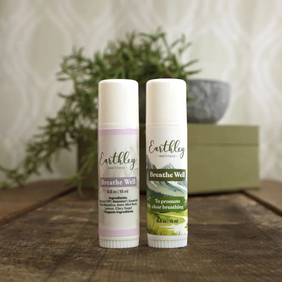 Two Earthly Wellness Breathe Well products on a wooden surface with a plant in the background.