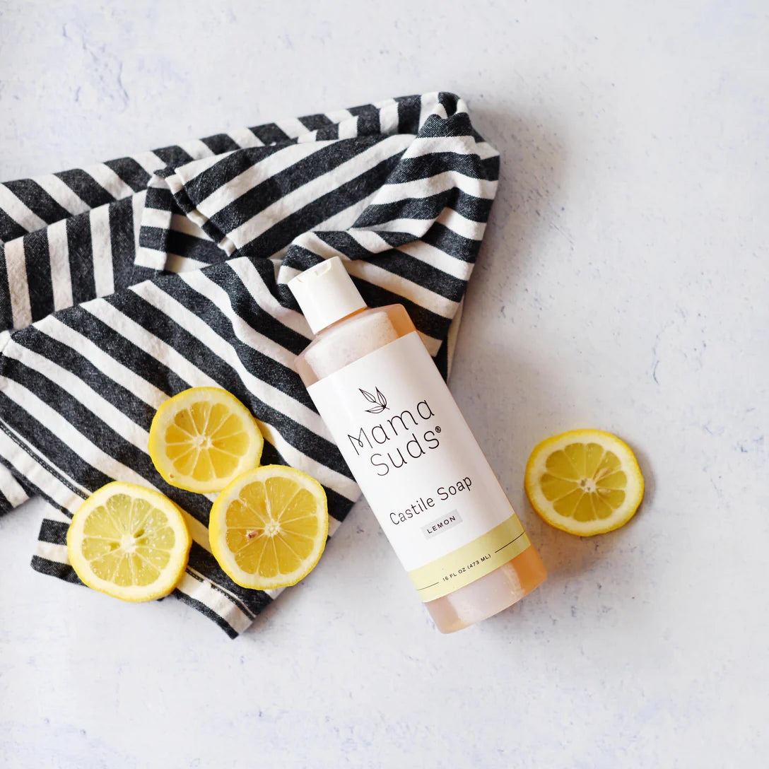 Mama Suds castile soap bottle with lemons and a striped towel on a light background