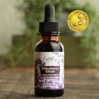 Bottle of Earthley Elderberry Elixir on a wooden surface with a blurred green background