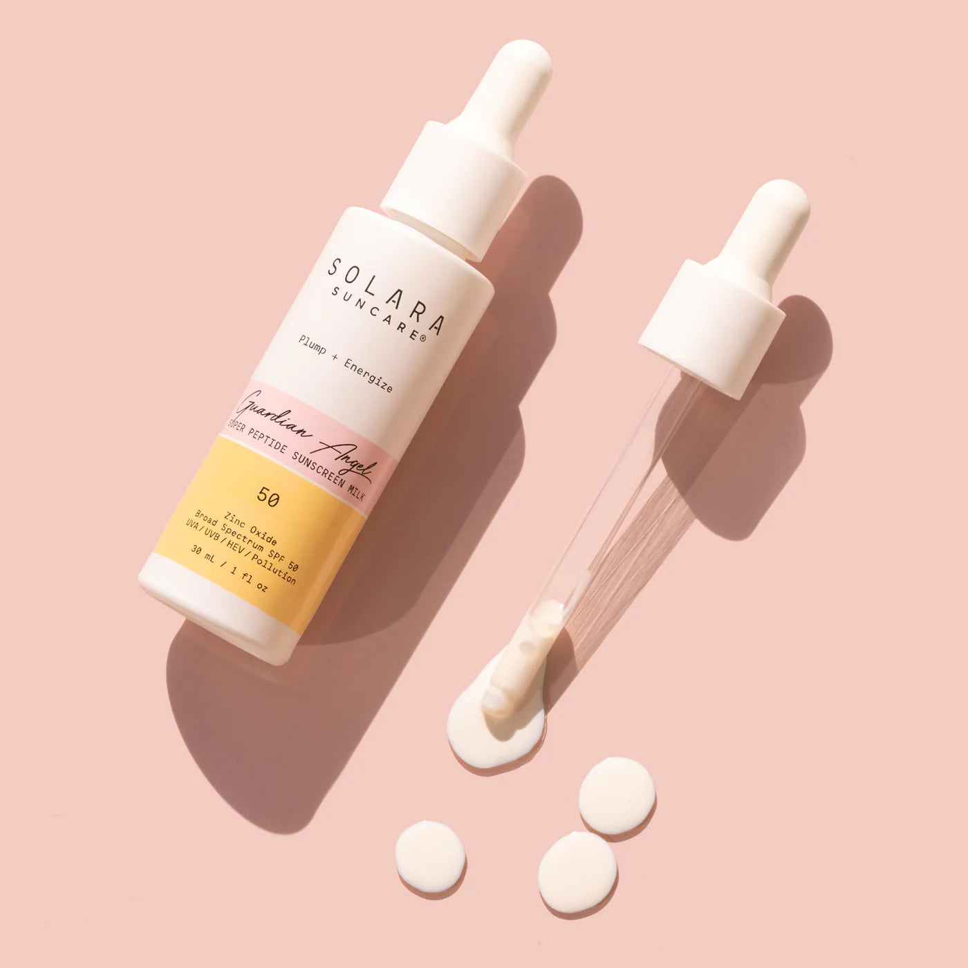 A dropper bottle of Solara Suncare displayed on a light pink background. The bottle is upright with liquid on the dropper. Three small white circles rest nearby.