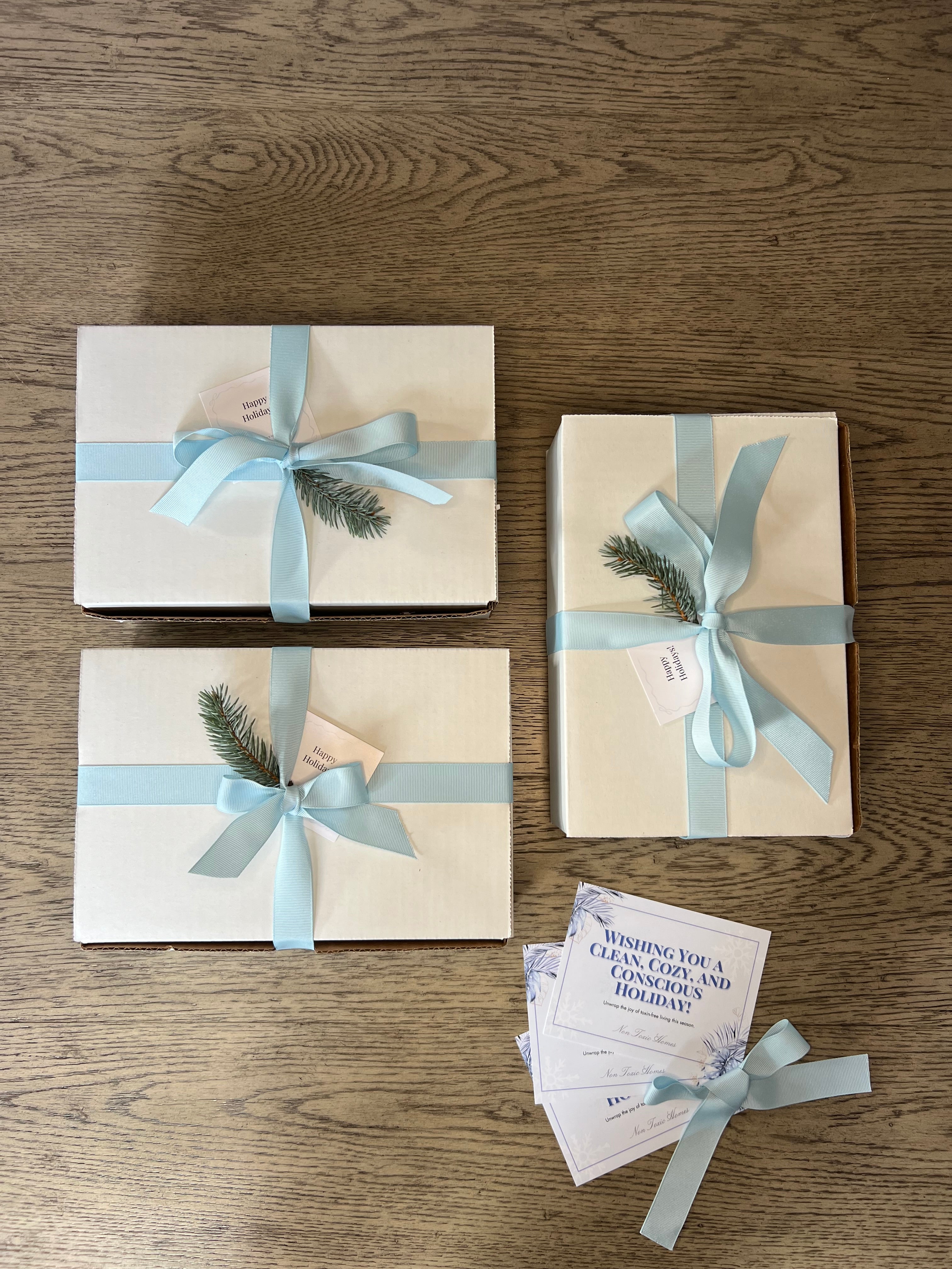 Three gift boxes with ribbons and tags on a wooden surface