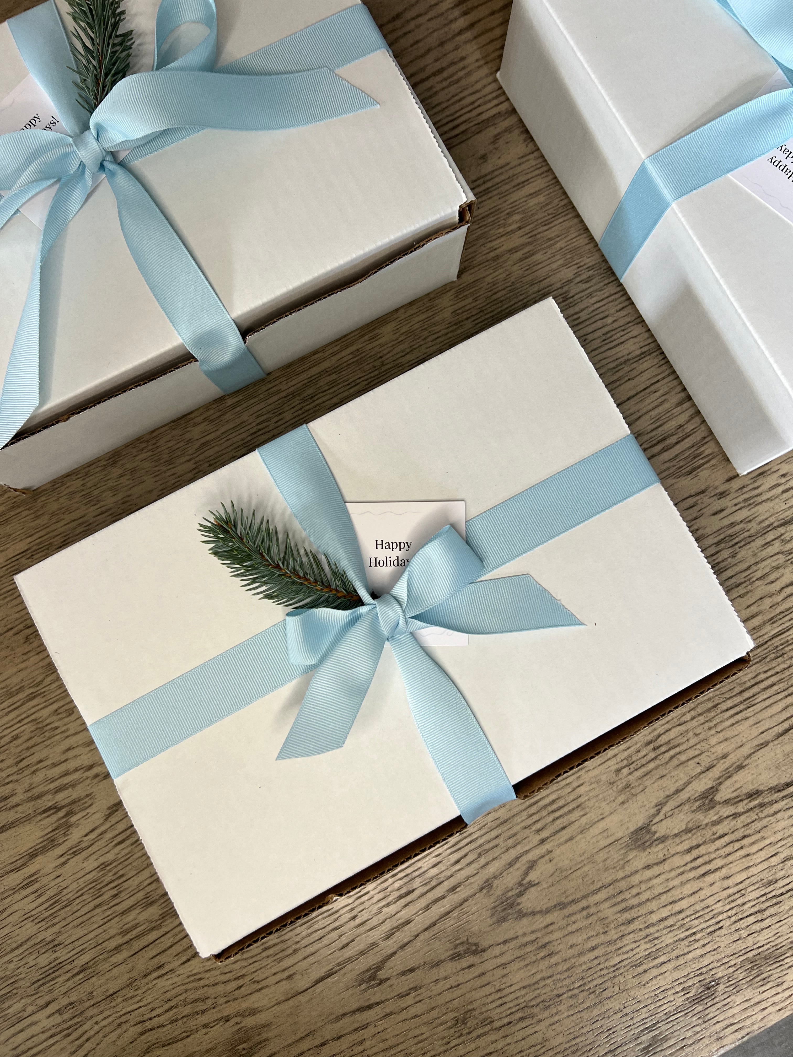 Another gift boxes with light blue ribbons on a wooden surface