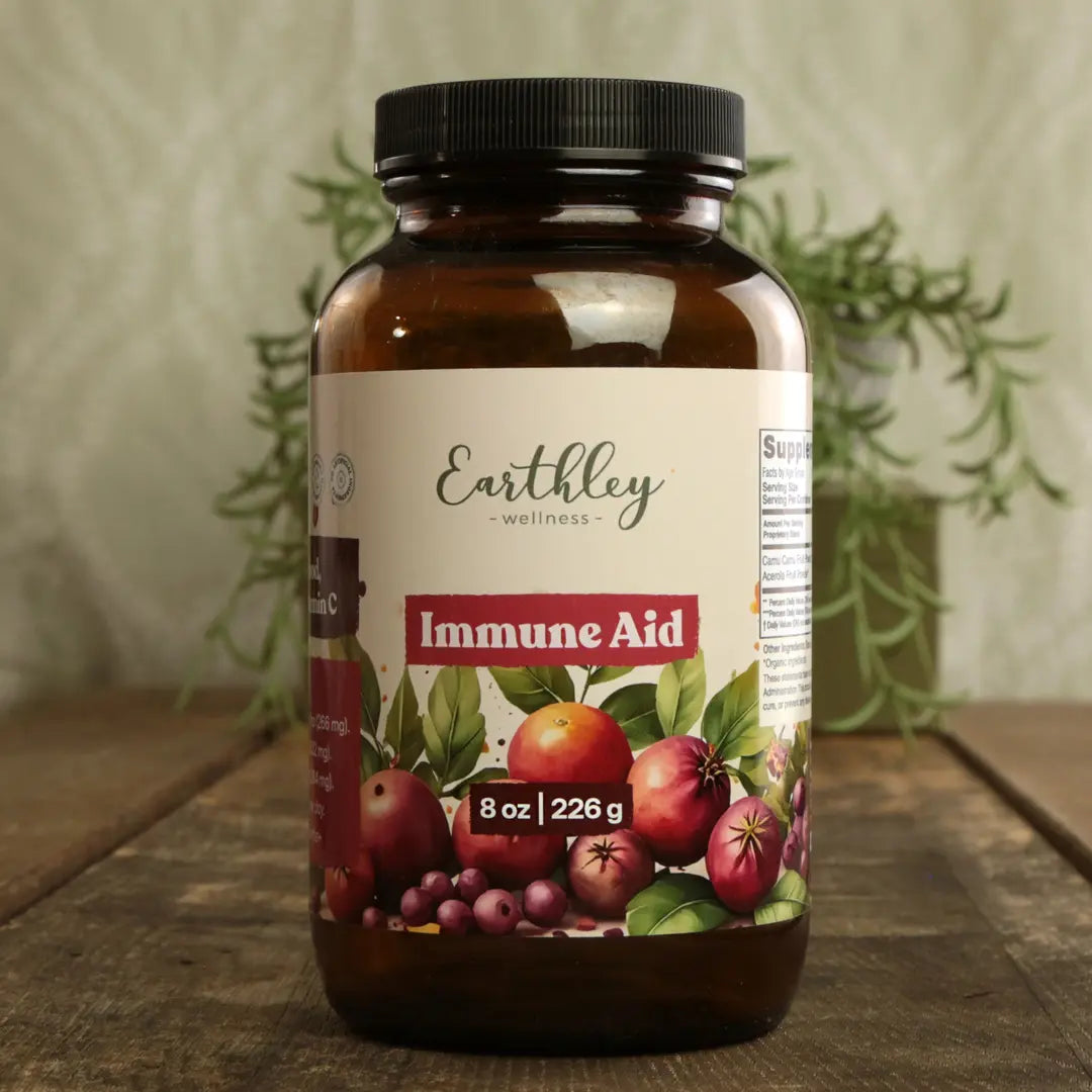 Bottle of Earthly Wellness Immune Aid on a wooden surface with a plant in the background