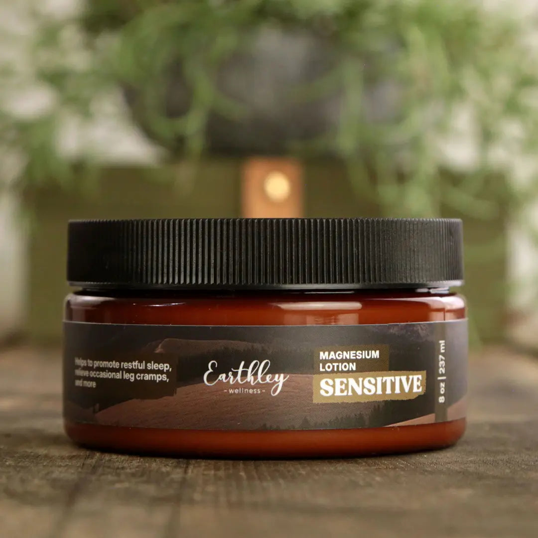 Earthley magnesium lotion jar with a black lid on a wooden surface