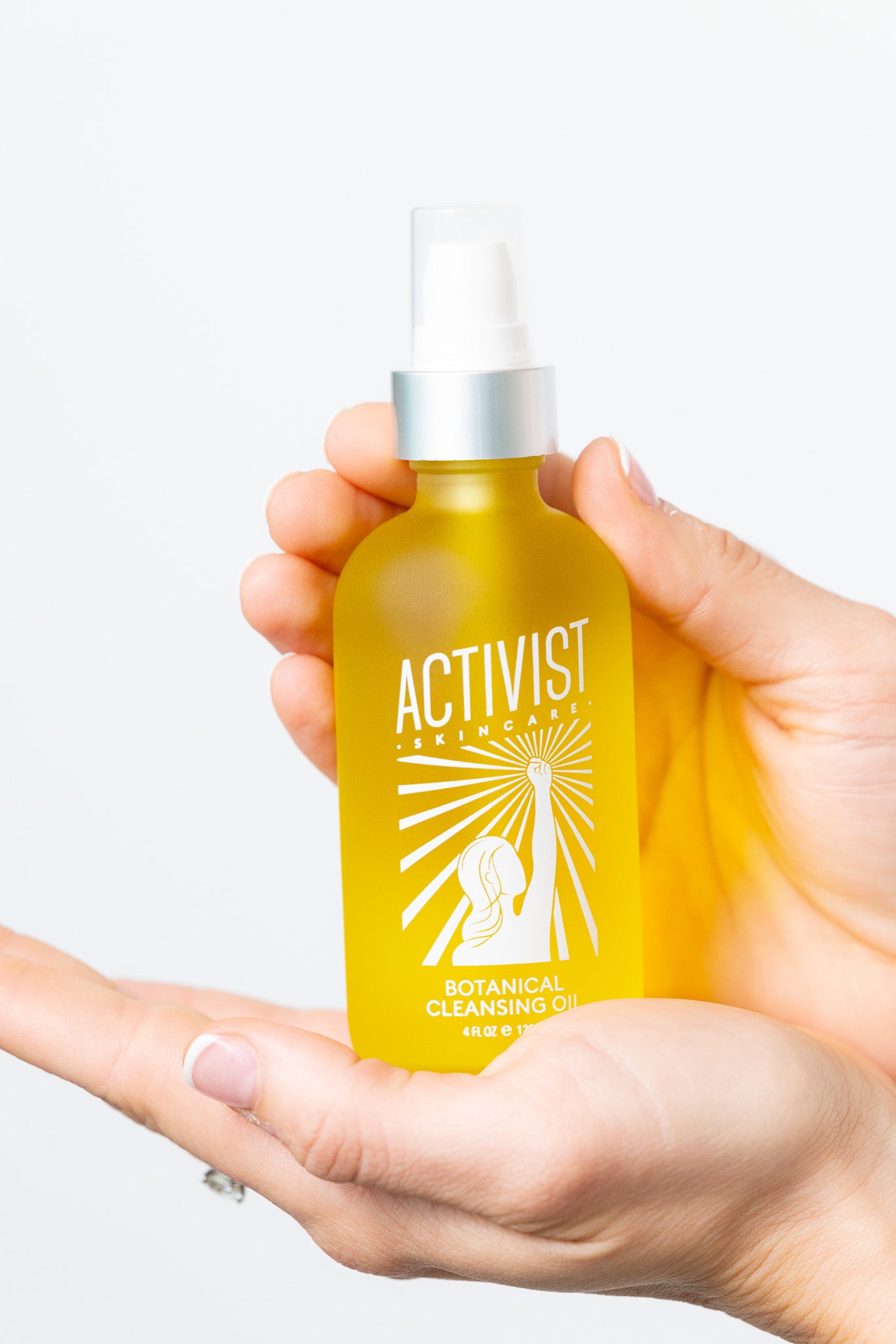Hand holding a yellow bottle with a white label against a light background