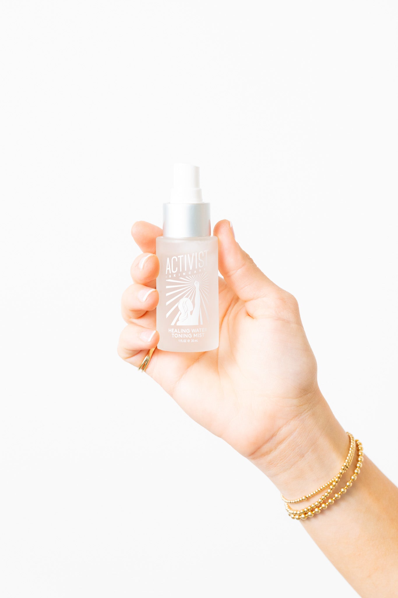 Hand holding a small bottle with a dropper against a white background