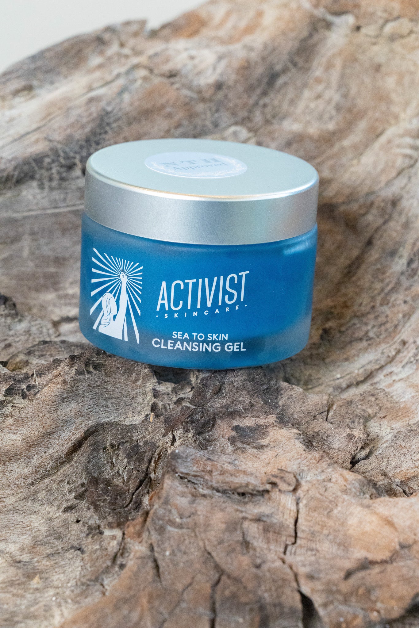 Blue jar of Activist Skincare cleansing gel on a wooden surface