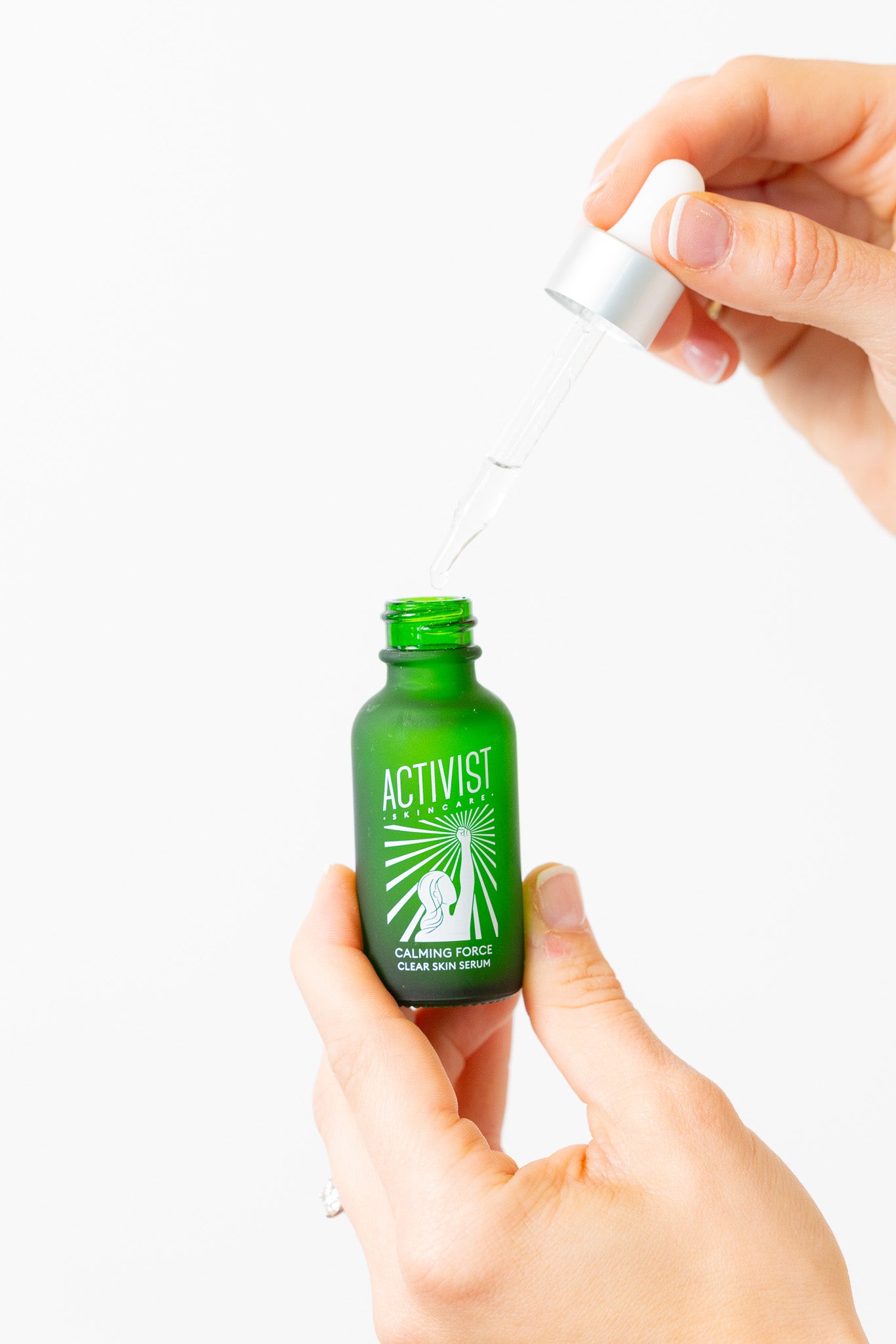 Green bottle labeled 'Activist' with a dropper held by a hand against a white background