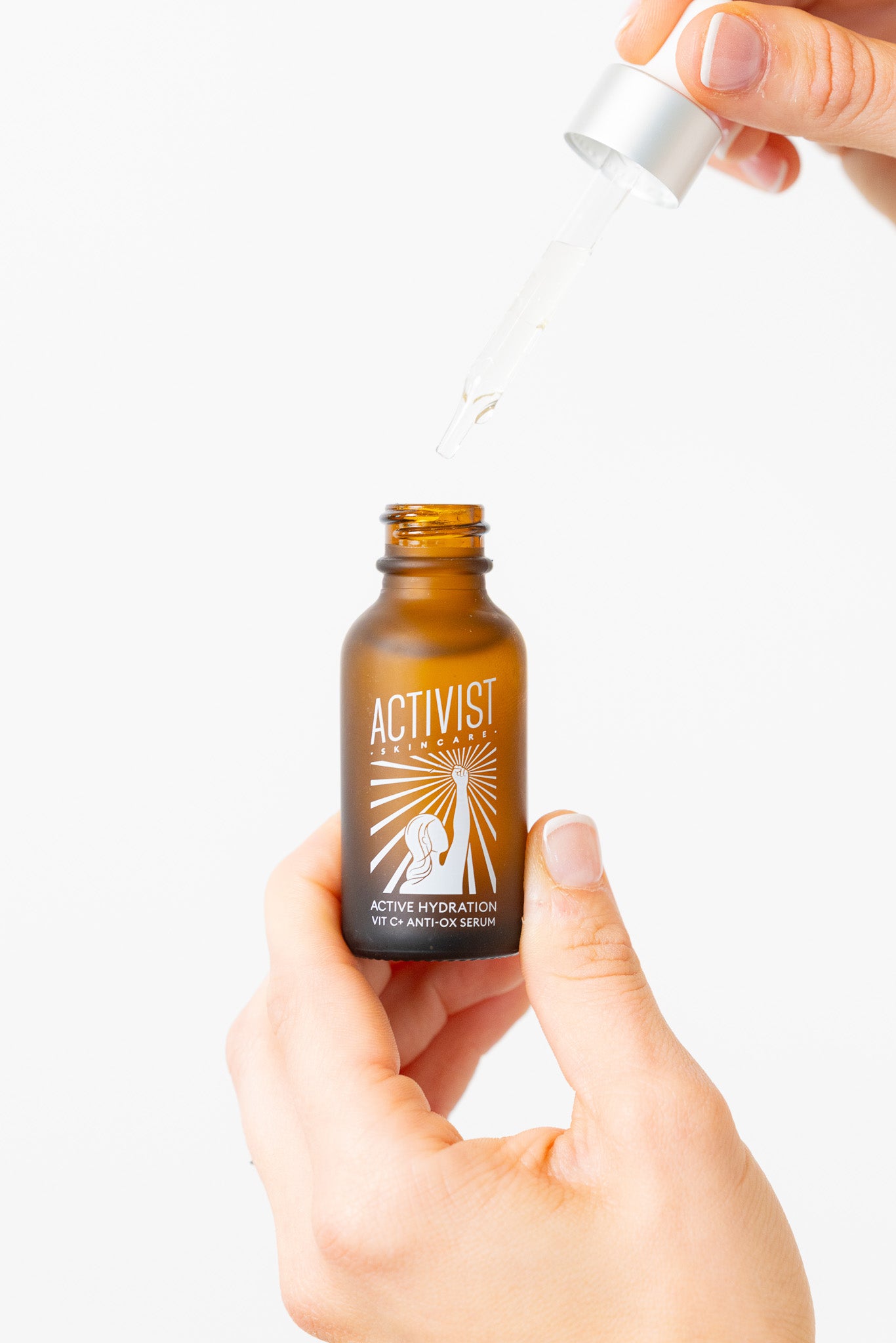 Bottle of Activist skincare serum with a dropper being used on a white background