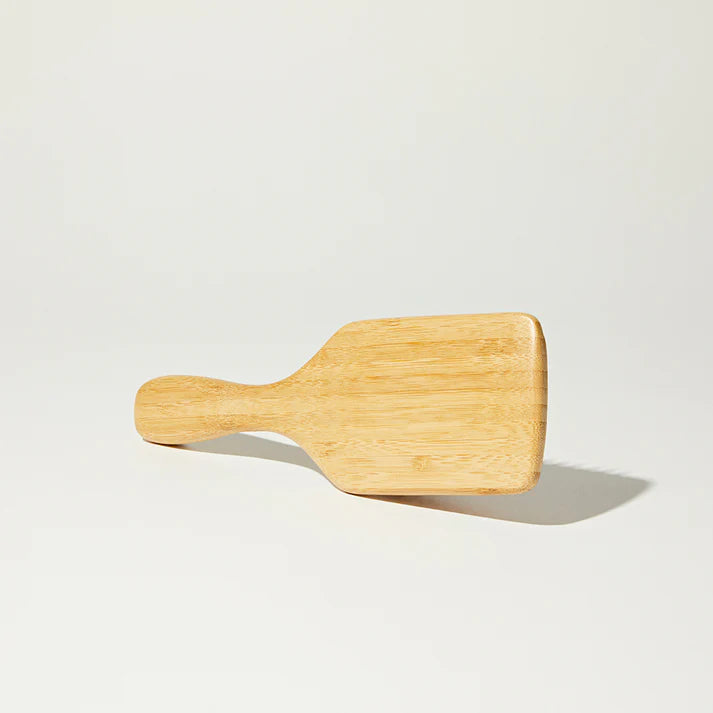 Wooden paddle on a light gray background