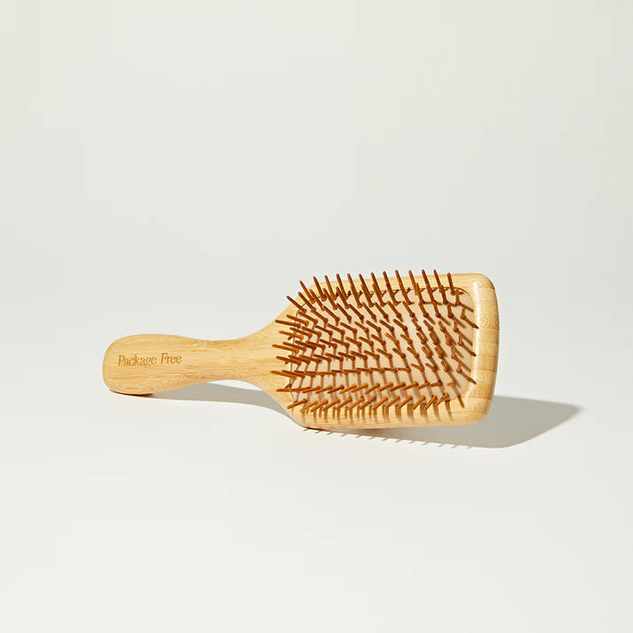 Wooden hairbrush on a light gray background