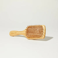 Wooden hairbrush on a light gray background