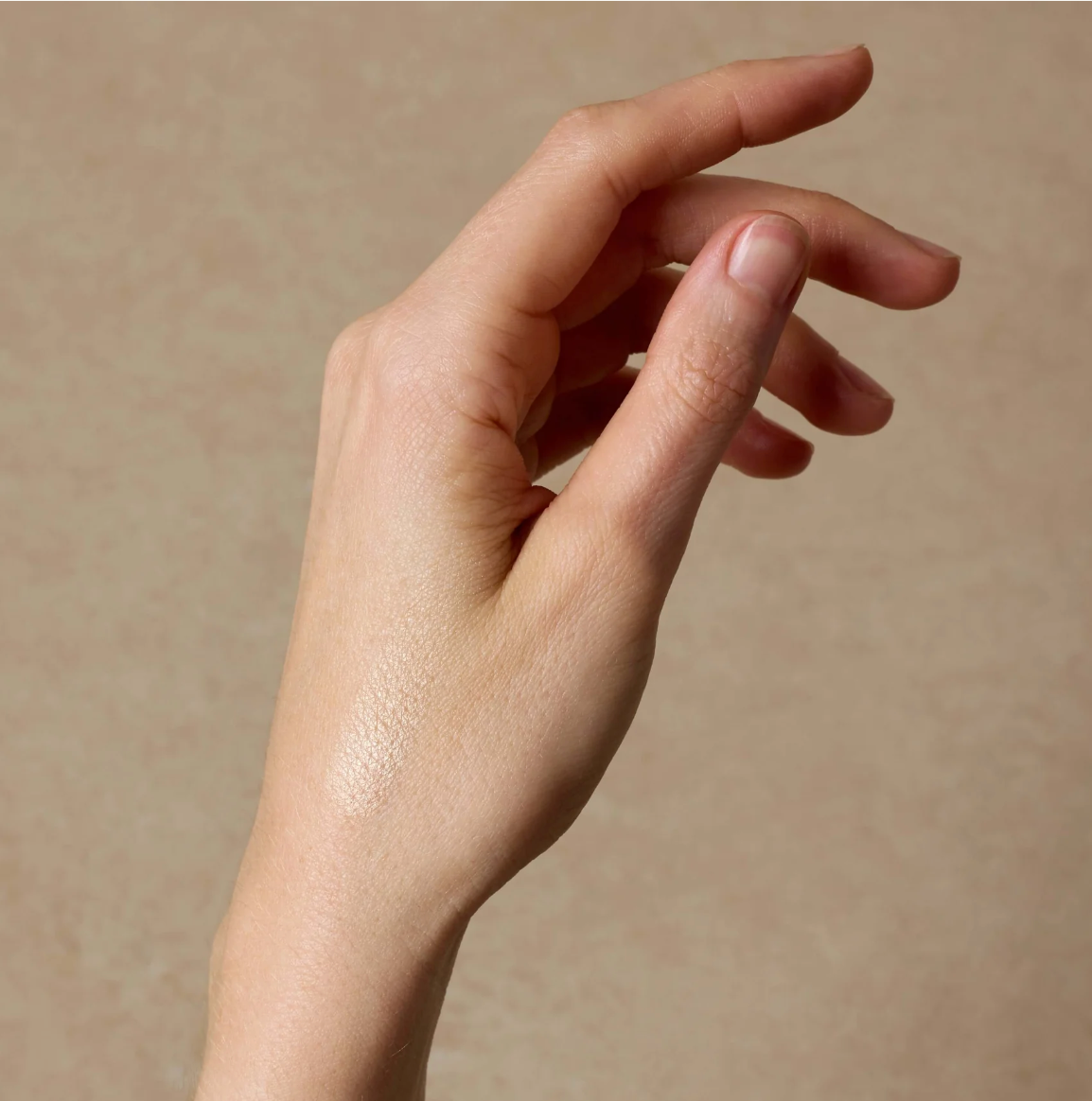 Close-up of a hand on a beige background