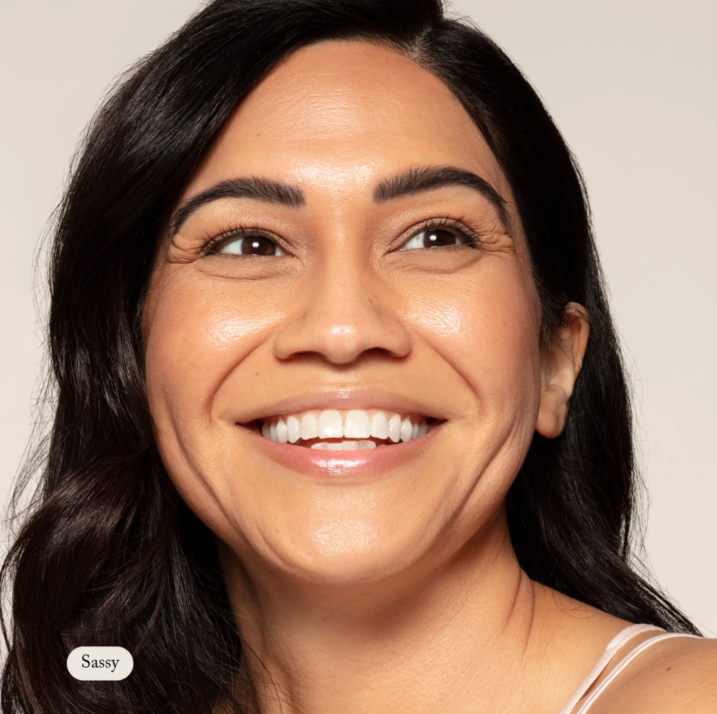 Woman with a bright smile on a plain background
