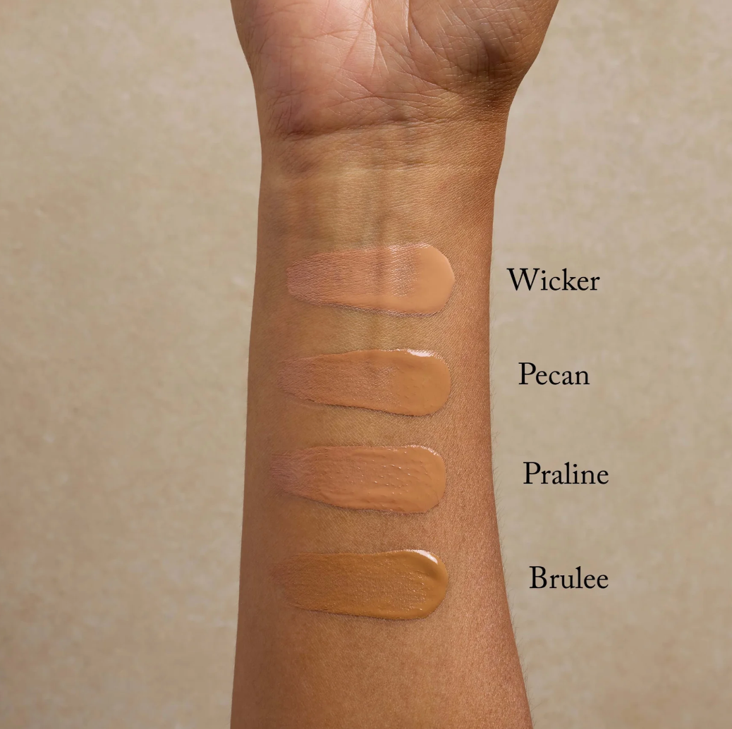 Swatches of different beige tones on a person's arm with labels 'Wicker', 'Pecan', 'Praline', and 'Brulee'.