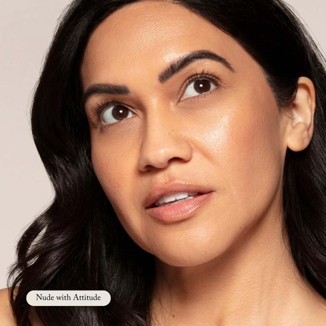 Close-up of a woman with dark hair and neutral makeup on a beige background