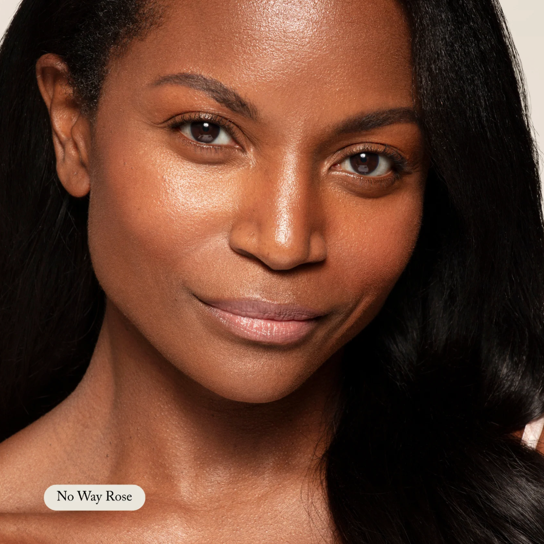 Close-up of a woman with long dark hair, wearing a 'No Way Rose' product.