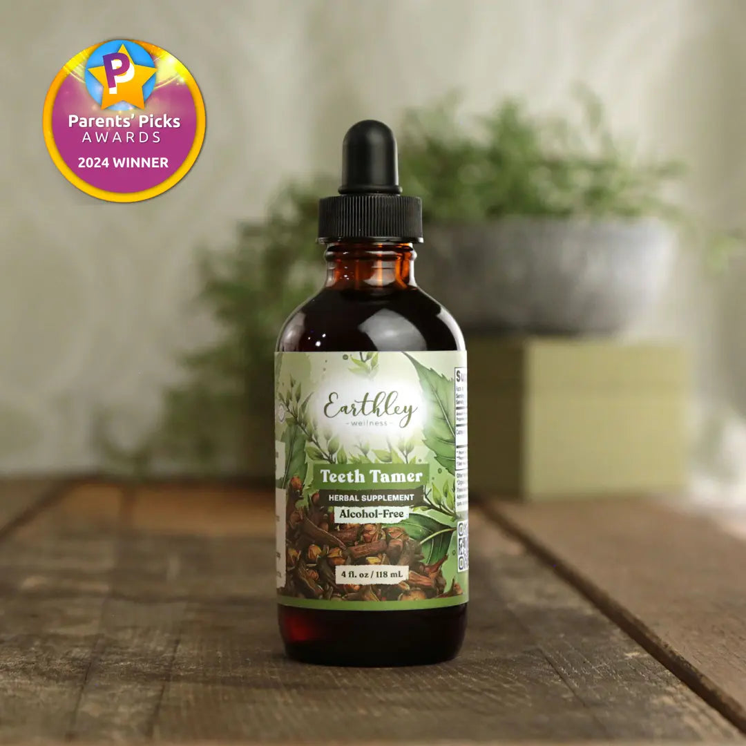 Bottle of Earthly Teeth Tamer supplement on a wooden surface with a blurred plant background.
