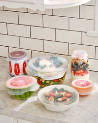 Set of food storage containers with lids on a kitchen counter.