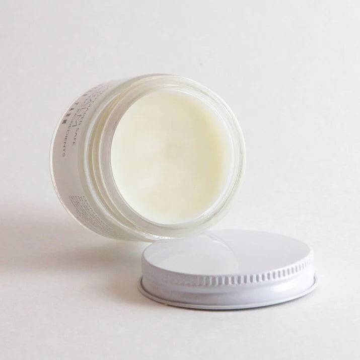 Open jar of cream with a white lid on a light gray background