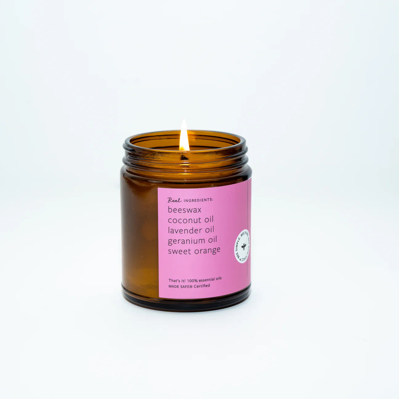 Candle in a brown jar with a pink label on a white background